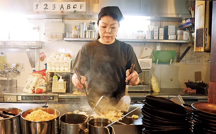 スタッフの在田さんがカウンター内のメイン鉄板で調理。鮮やかなコテさばきで具材や麺を炒めます