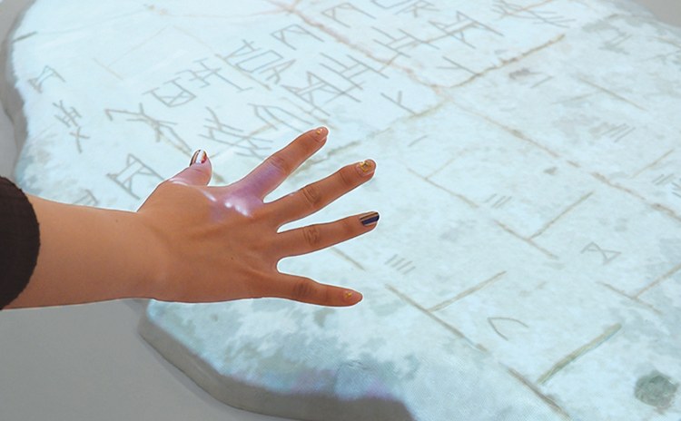 手をかざすと漢字が動き出す「踊る甲骨文字テーブル」。漢字に触れると、ルーツである甲骨文字に変わります