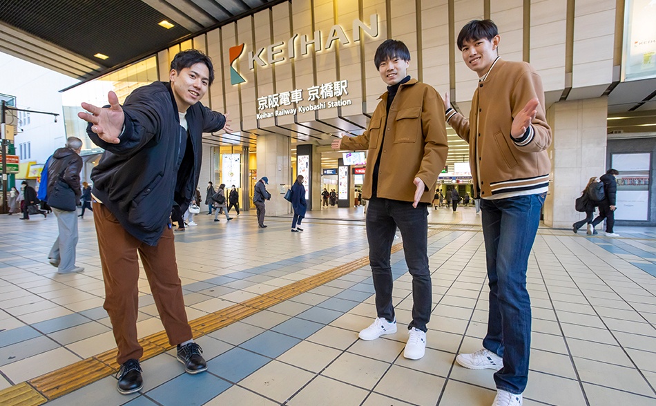 京橋駅での撮影中、行き交う人が多く、ポーズをとるのに少し照れる選手たち。高身長（左から仲本選手187cm、大塚選手194cm、西山選手193cm）の3人が集まると、周りの人たちに注目される。